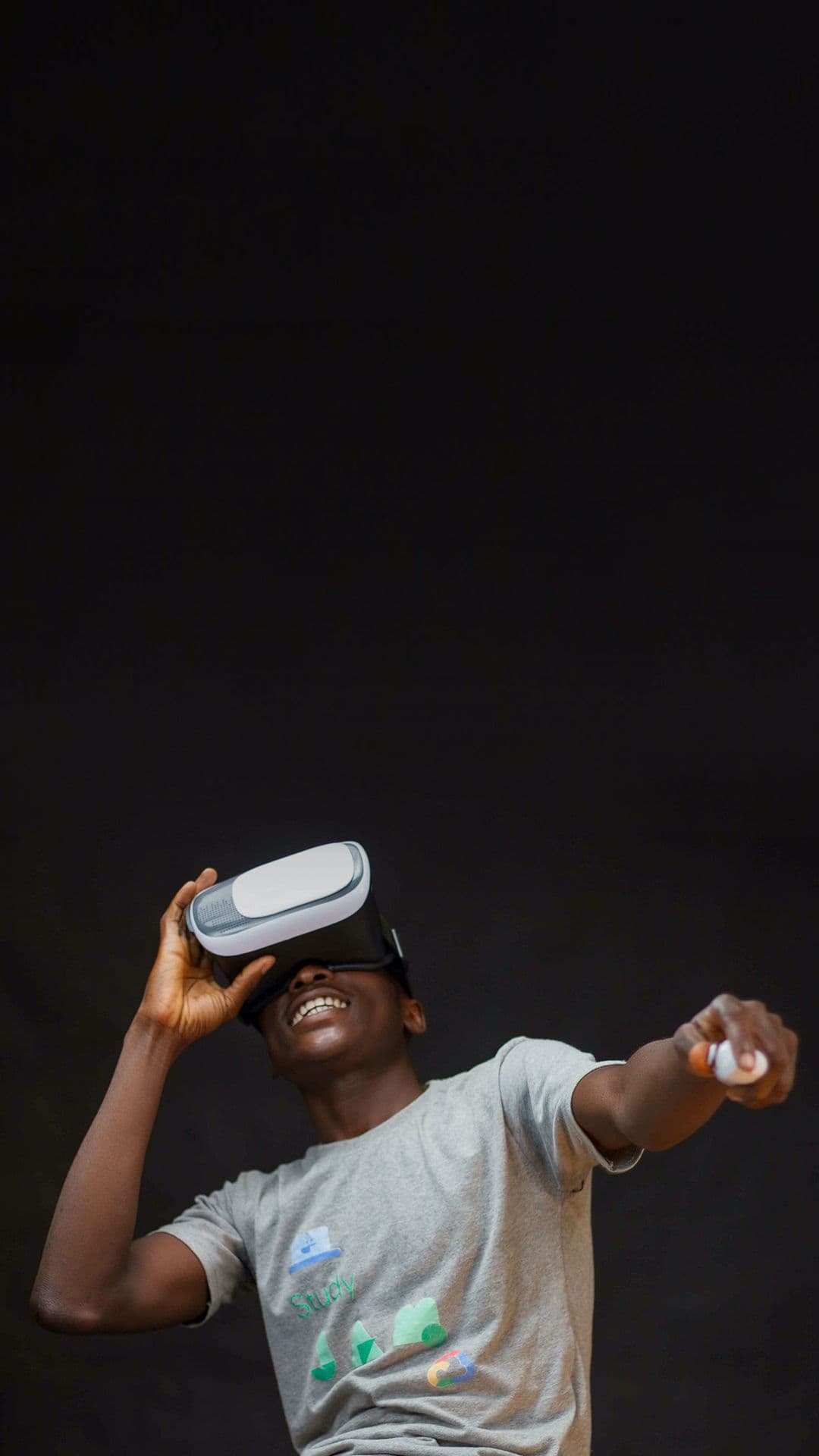 Dunkelhäutiger Junge im hellen T-Shirt trägt eine VR-Brille